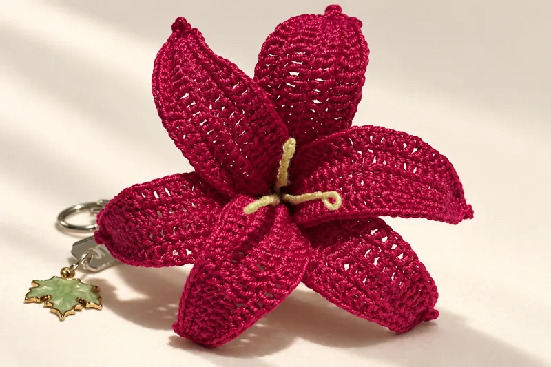 A close-up of a crocheted crimson lily