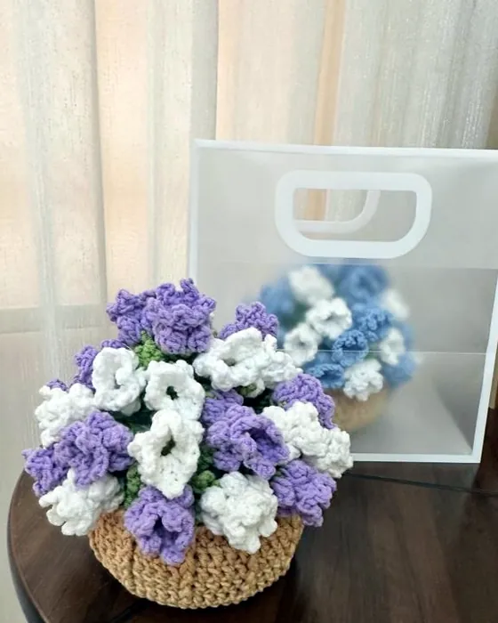 A basket of crocheted lilac flowers